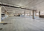 Thumbnail 7 of 20 - A large, empty parking garage with concrete pillars and floors.