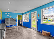 Thumbnail 5 of 26 - A blue and yellow kitchen with a large window.