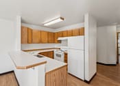 Thumbnail 21 of 21 - A white kitchen with wooden cabinets and a white fridge.