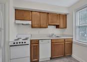 Thumbnail 19 of 21 - A kitchen with white appliances and wooden cabinets.