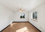 Thumbnail 18 of 21 - A room with a ceiling fan and two windows.
