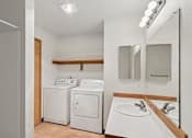 Thumbnail 17 of 21 - A small bathroom with a washer and dryer.
