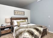 Thumbnail 9 of 20 - a bedroom with a bed and a nightstand
