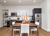 Thumbnail 6 of 20 - an open kitchen and dining area with a wooden table and white chairs