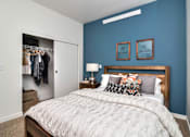 Thumbnail 8 of 20 - a bedroom with a large bed in front of a blue wall