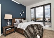 Thumbnail 4 of 20 - a bedroom with a large window and a bed with a wooden headboard