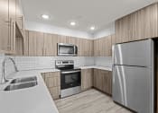 Thumbnail 9 of 30 - a kitchen with stainless steel appliances and wooden cabinets