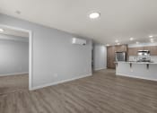 Thumbnail 13 of 30 - an empty living room and kitchen with wood flooring and white walls