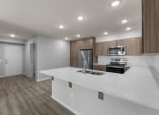 Thumbnail 14 of 30 - an empty kitchen with a white counter top and a stainless steel stove and refrigerator