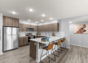 Thumbnail 1 of 30 - a kitchen with a large island and a stainless steel refrigerator
