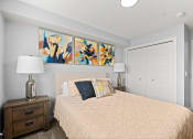 Thumbnail 5 of 30 - a bedroom with a bed and paintings on the wall