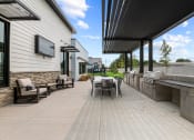 Thumbnail 27 of 30 - the outdoor patio has a grill and a table with chairs