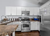 Thumbnail 2 of 11 - a kitchen with stainless steel appliances and white cabinets
