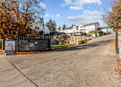 Thumbnail 5 of 11 - the front driveway of a house with a stone fence and a sign that reads new