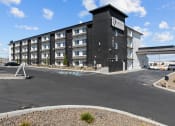 Thumbnail 4 of 5 - a large black building with a parking lot in front of it
