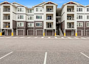 Thumbnail 37 of 38 - A large parking lot in front of apartment buildings.