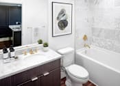 Thumbnail 11 of 35 - A bathroom with a white toilet and a white bathtub.