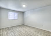 Thumbnail 11 of 26 - an empty room with wood flooring and a window
