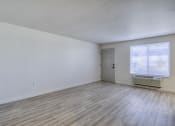 Thumbnail 7 of 26 - the spacious living room of an apartment with wood flooring and a door to a