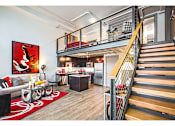 Thumbnail 1 of 20 - A living room with a red rug and a painting on the wall.