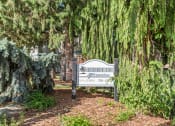 Thumbnail 7 of 15 - Curtis Apartments sign in front of some trees and plants