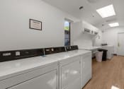 Thumbnail 15 of 15 - Curtis Apartments laundry room is equipped with washer and dryer and a window