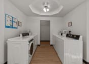 Thumbnail 14 of 15 - Curtis Apartments laundry room with washes and dryers