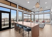 Thumbnail 11 of 20 - a kitchen and living room with large windows and a table and chairs
