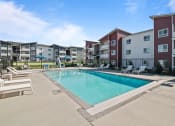 Thumbnail 9 of 21 - a swimming pool in front of an apartment building