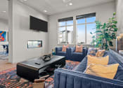 Thumbnail 2 of 21 - a living room with blue couches and a tv