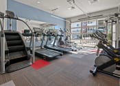 Thumbnail 6 of 21 - a gym with treadmills and other exercise equipment in a building with a balcony
