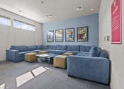 Thumbnail 3 of 21 - a living room with couches and chairs and posters on the wall