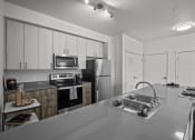 Thumbnail 14 of 21 - a kitchen with stainless steel appliances and a sink