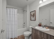 Thumbnail 20 of 21 - a bathroom with a shower and a sink and a toilet