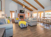 Thumbnail 11 of 13 - A living room with a grey couch, yellow throw pillows, and a fireplace.