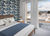 Thumbnail 6 of 35 - A bedroom with a large bed and a view of a bridge.