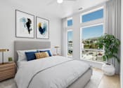 Thumbnail 4 of 22 - A bedroom with a large bed, two lamps, and two framed artworks on the wall.