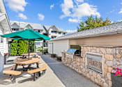 Thumbnail 7 of 12 - an outdoor patio with picnic tables and a stone fireplace