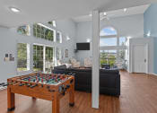 Thumbnail 19 of 34 - a living room with a couch and a table with a pool table