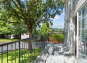 Thumbnail 10 of 34 - the view from the deck of a home with a large tree and a balcony