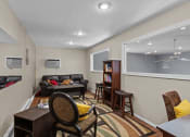 Thumbnail 16 of 34 - a living room with a couch and a table and a window