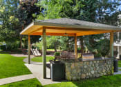 Thumbnail 8 of 34 - a stone patio with a pavilion with a grill