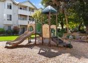 Thumbnail 4 of 34 - a playground with a slide and a swing set in front of an apartment building