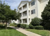 Thumbnail 16 of 20 - a white apartment building with a sidewalk in front of it