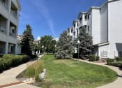 Thumbnail 15 of 20 - an apartment building with a lawn and trees in front of it