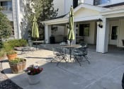Thumbnail 5 of 20 - a patio with tables and umbrellas in front of a house