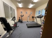 Thumbnail 6 of 20 - a gym with treadmills and other exercise equipment in a small room
