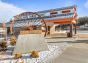 Thumbnail 30 of 31 - a large wheel sits in front of a building with snow on the ground