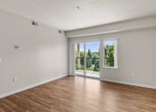 Thumbnail 17 of 45 - a bedroom with hardwood floors and a sliding glass door leading to a balcony