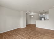 Thumbnail 10 of 45 - an empty living room with a kitchen in the background